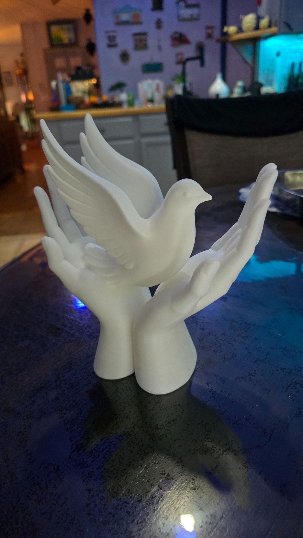 White 3D printed dove held by sculpted hands